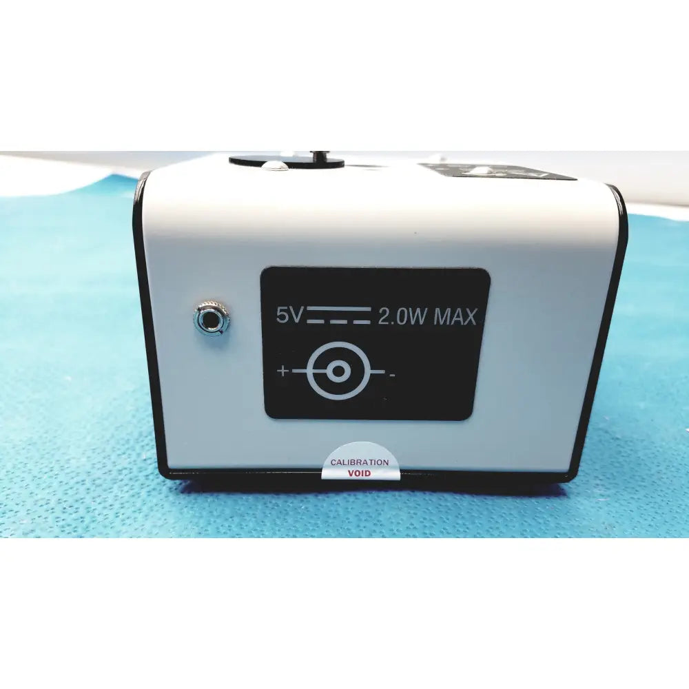 White rectangular welch allyn 9600 plus calibration tester with black trim power input label and calibration void sticker