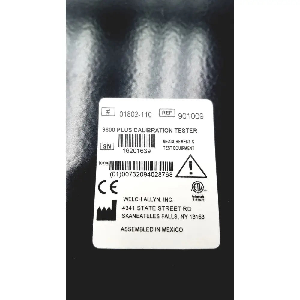 White rectangular label with black text on welch allyn 9600 plus calibration tester indicating model and specifications