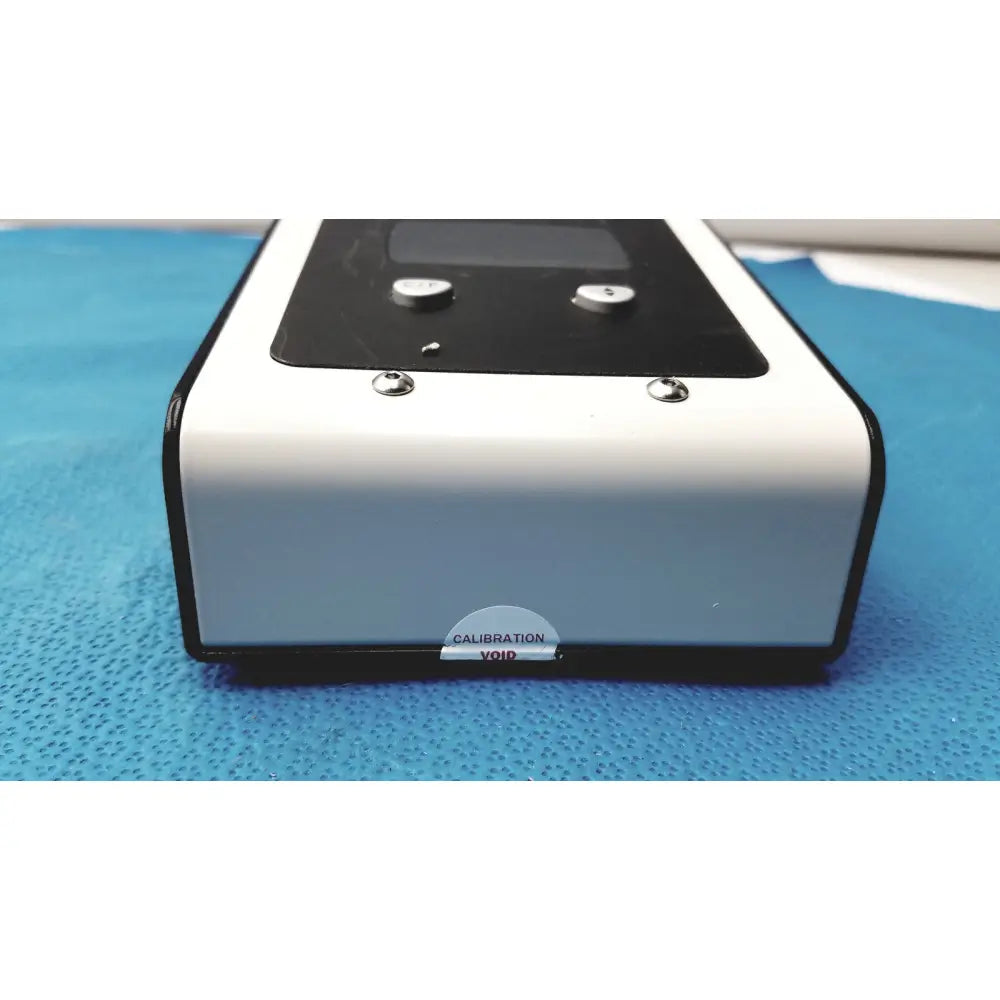 White and black rectangular welch allyn 9600 plus calibration tester with digital display silver buttons and calibration void sticker