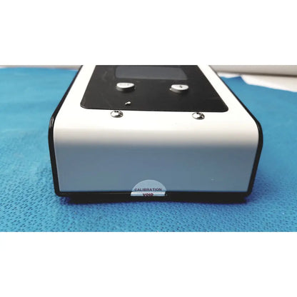 White and black rectangular welch allyn 9600 plus calibration tester with digital display silver buttons and calibration void sticker