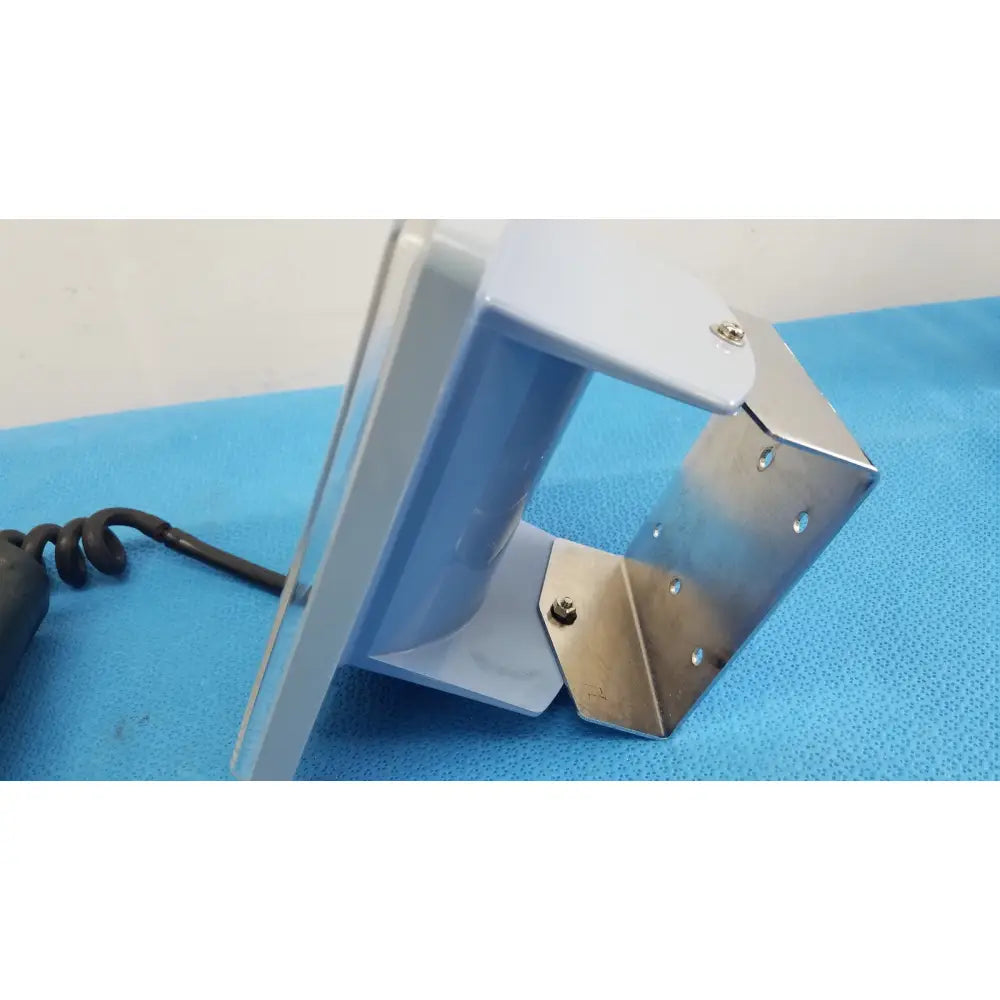 White and metallic wall mounted bracket with coiled black cable for welch allyn adult blood presure cuff sphygmomanometer
