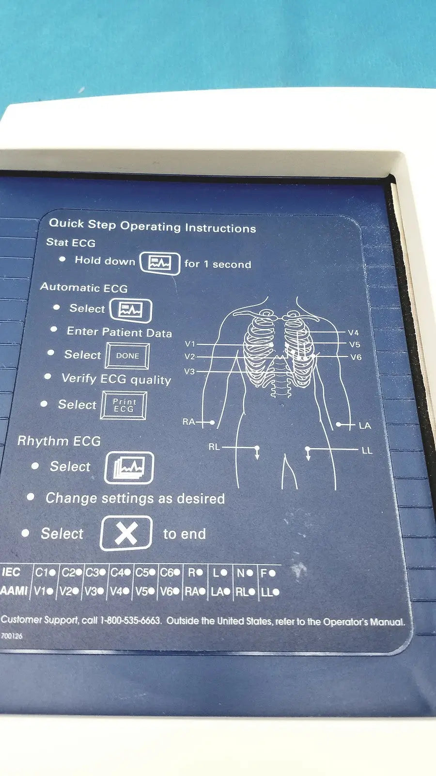 Blue plastic panel with white instructions and diagram on the back of welch allyn cp 200 ekg ecg monitor