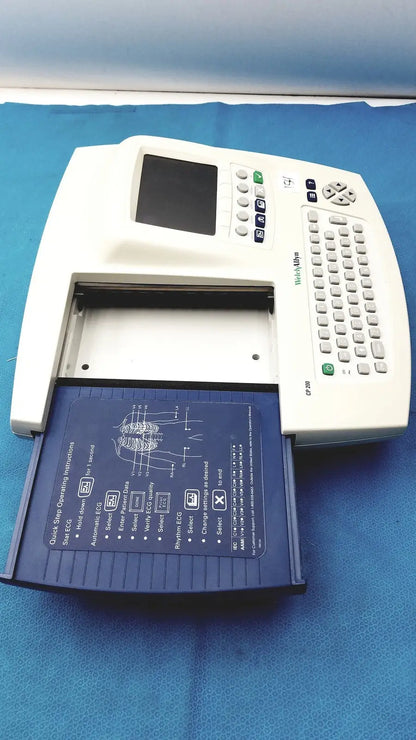 White welch allyn cp 200 ekg ecg monitor with blue paper tray showing anatomical diagrams and operational instructions
