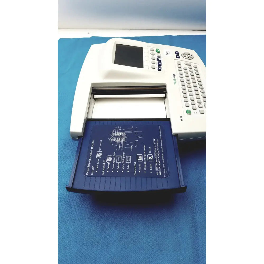 White welch allyn cp200 ekg monitor with blue paper tray showing diagnostic instructions and diagrams