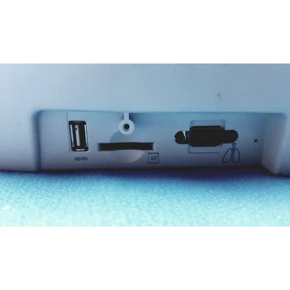 White plastic back side of welch allyn cp200 ekg monitor with usb port sd card slot and circular cable hole