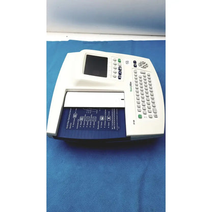 White welch allyn cp200 ekg monitor with small screen gray keypad and blue paper tray labeled widal 53 for ecg recording