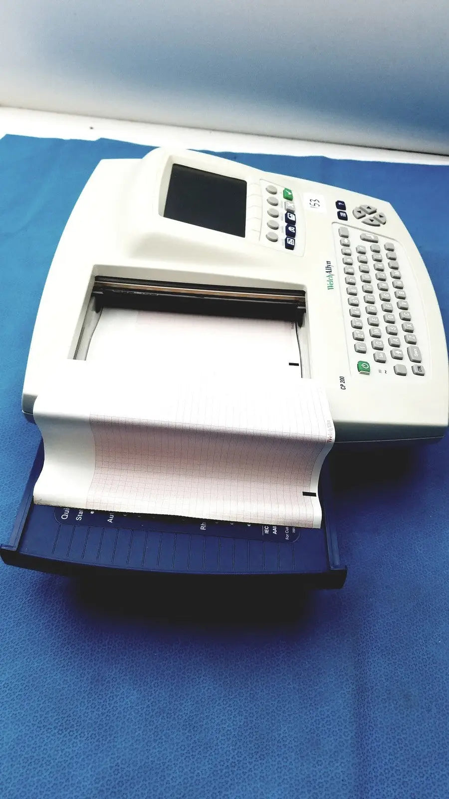 White and blue welch allyn cp200 ekg machine with digital display keypad and paper output tray for cardiac monitoring