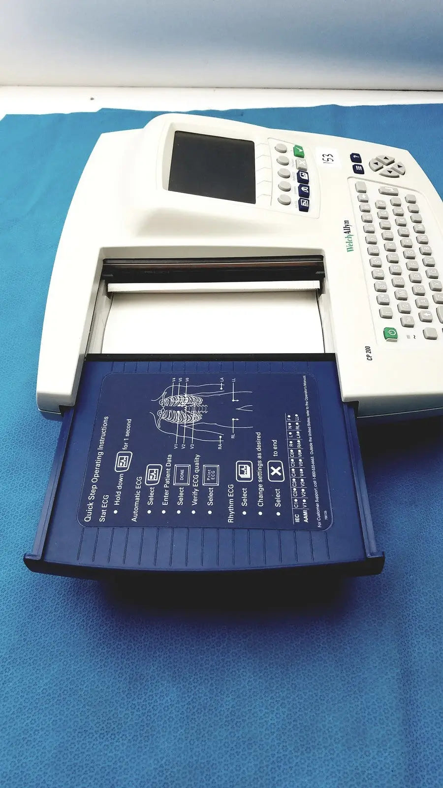 White welch allyn cp200 ekg monitor with blue paper tray showing diagnostic instructions and diagrams