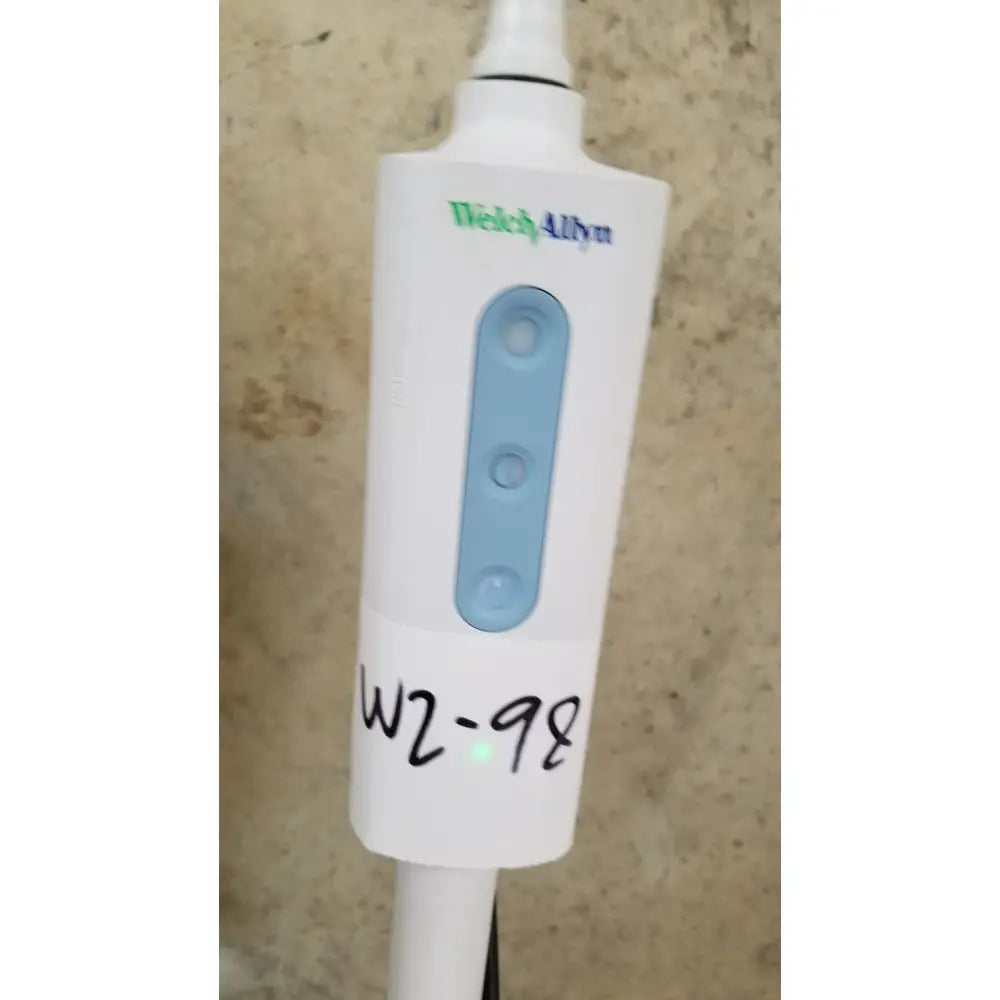Welch allyn gs 600 exam light with rolling stand featuring white device, light blue control buttons, and a handwritten label