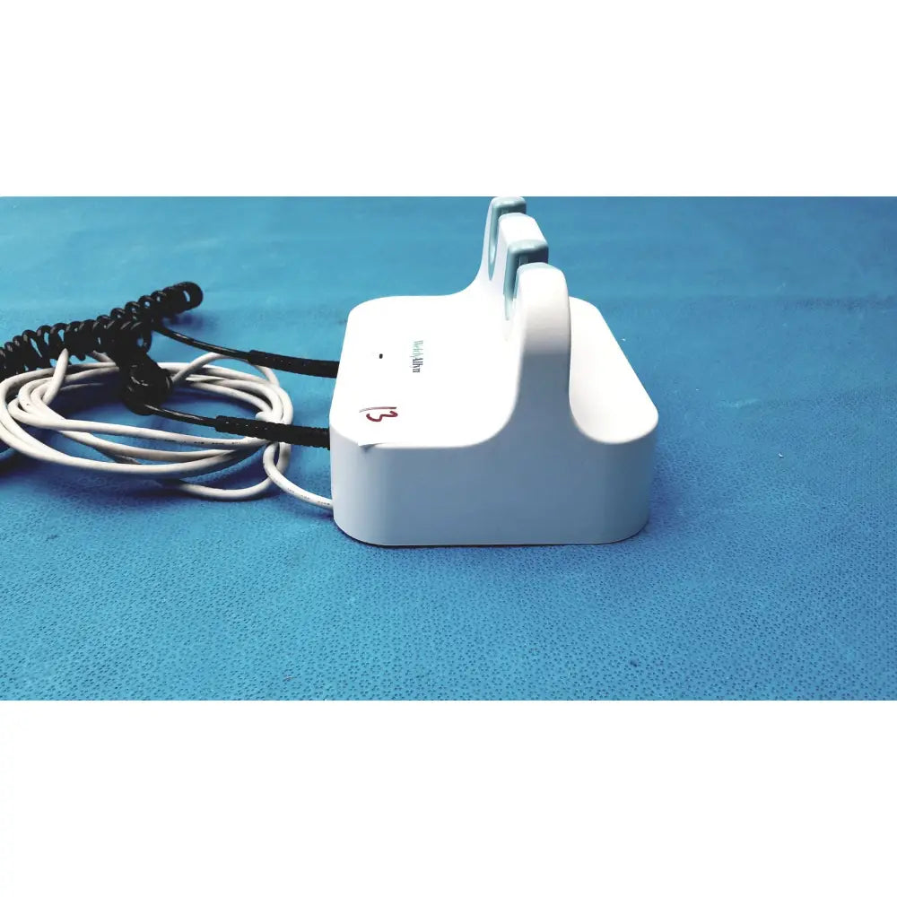 White plastic welch allyn wall transformer charging dock with coiled black and white reuse medical cables