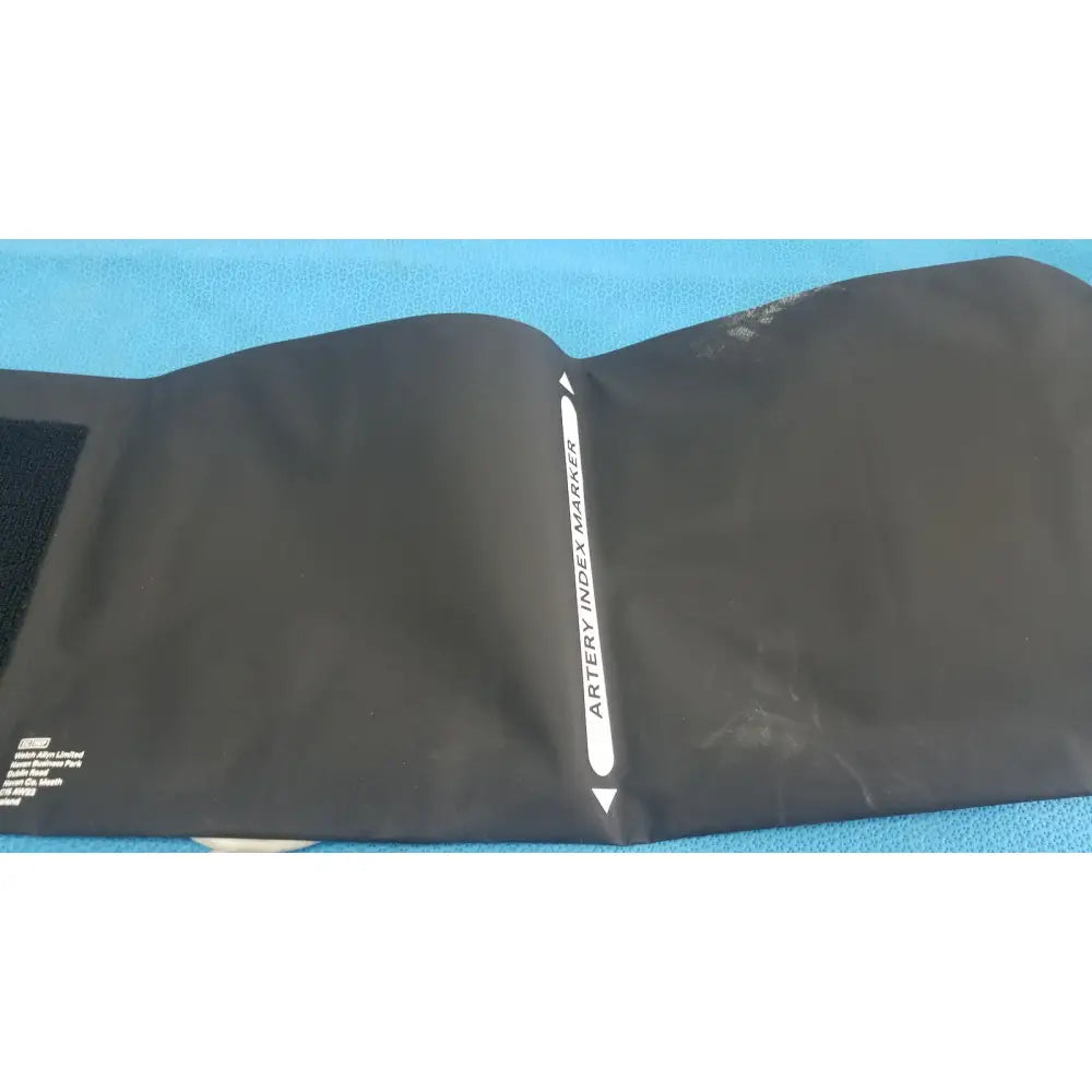 Black artery index marker with white text and arrows on blue welch allyn hillrom blood pressure cuff thigh 13 40-55cm