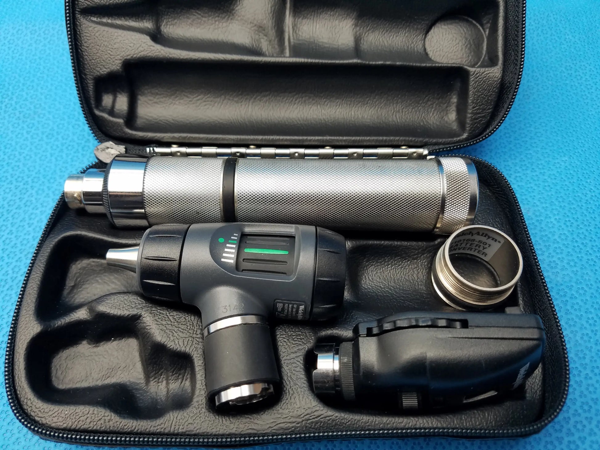 Silver and black welch allyn led macroview otoscope with led illumination, textured grip, digital display, and black leather case