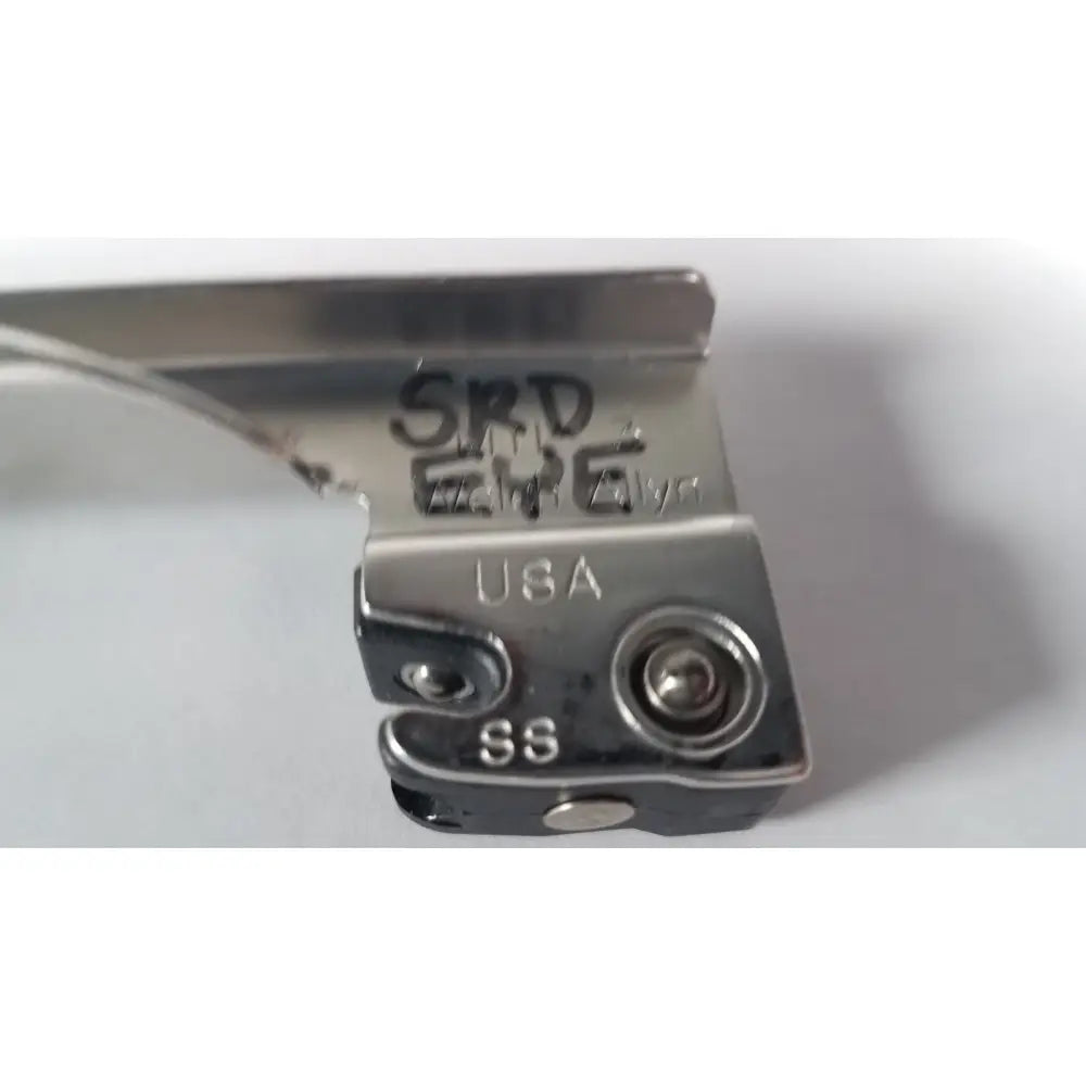 Silver metal presser foot with engraved markings and usa stamp on the back of a welch allyn miller laryngoscope blade size 3
