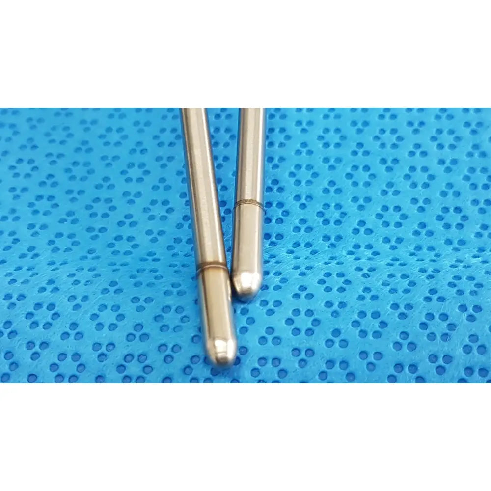 Two slender metallic silver welch allyn probe pins with rounded tips on a textured blue surface lot of 2
