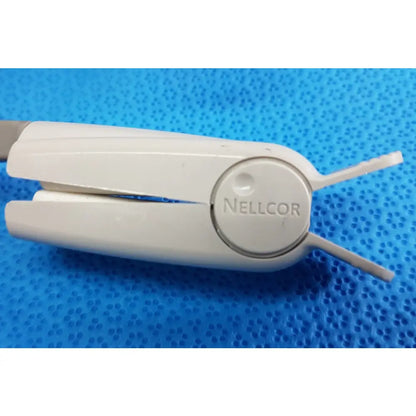 White plastic nellcor clip with rounded handles and two arms for welch allyn propaq encore 202 el patient monitor