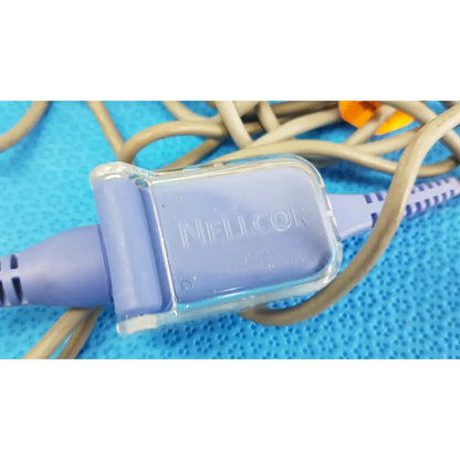 A translucent purple plastic connector with clear cap branded nellcor attached to a welch allyn propaq encore 202 el monitor cable