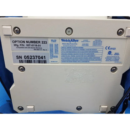 Back view of white plastic welch allyn propaq encore patient monitor option module with screw-fastened label detailing model and serial number