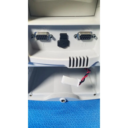 Back side of white plastic welch allyn spot vital signs lxi patient monitor with two silver db-9 serial ports and power connector