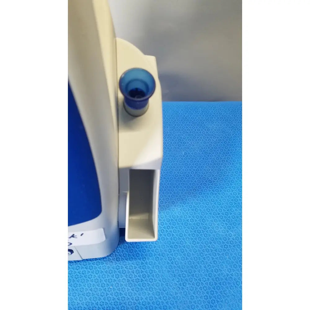 Beige and blue plastic medical device with small cylindrical opening part of welch allyn spot vital signs patient monitor