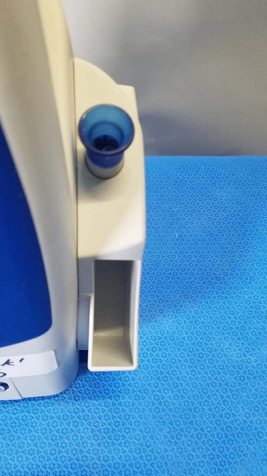 Beige and blue plastic medical device with small cylindrical opening part of welch allyn spot vital signs patient monitor