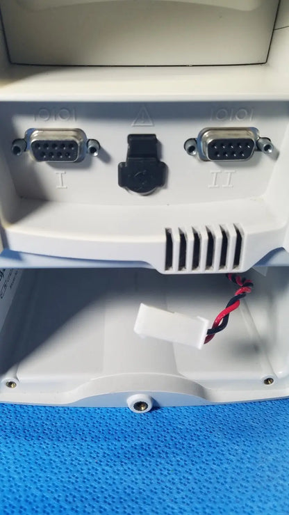 Back side of white plastic welch allyn spot vital signs lxi patient monitor with two silver db-9 serial ports and power connector