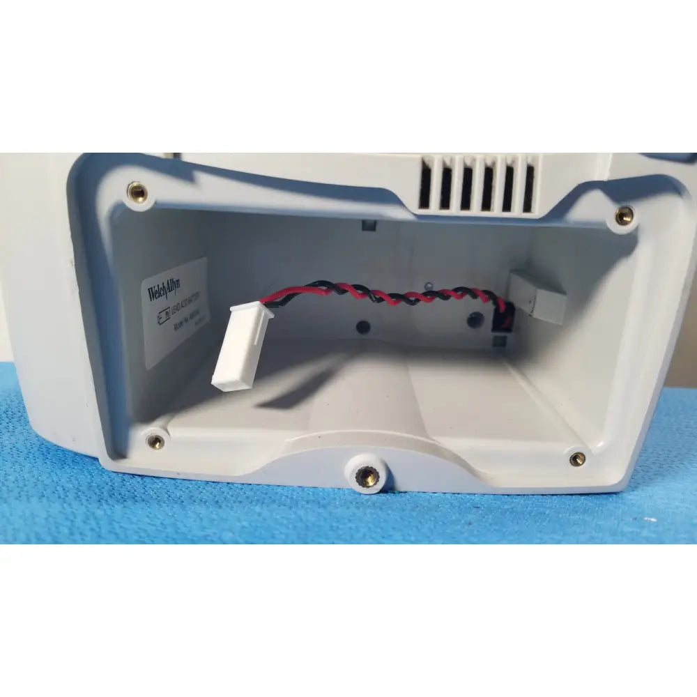 White and blue plastic housing with internal wiring visible on the back side of welch allyn spot vital signs lxi device