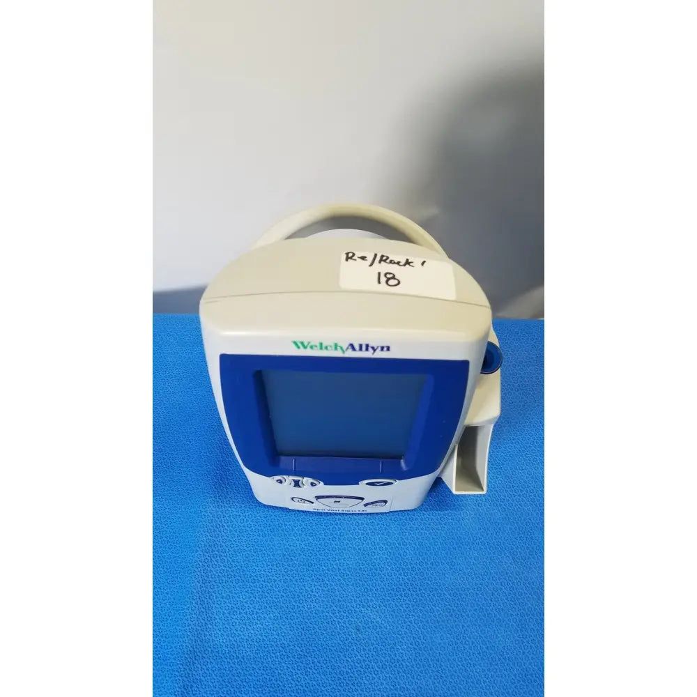 White and blue welch allyn spot vital signs LXi patient monitor with handle, screen, and control buttons