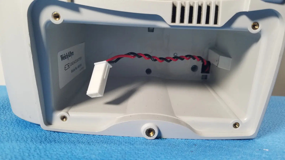 White and blue plastic housing with internal wiring visible on the back side of welch allyn spot vital signs lxi device