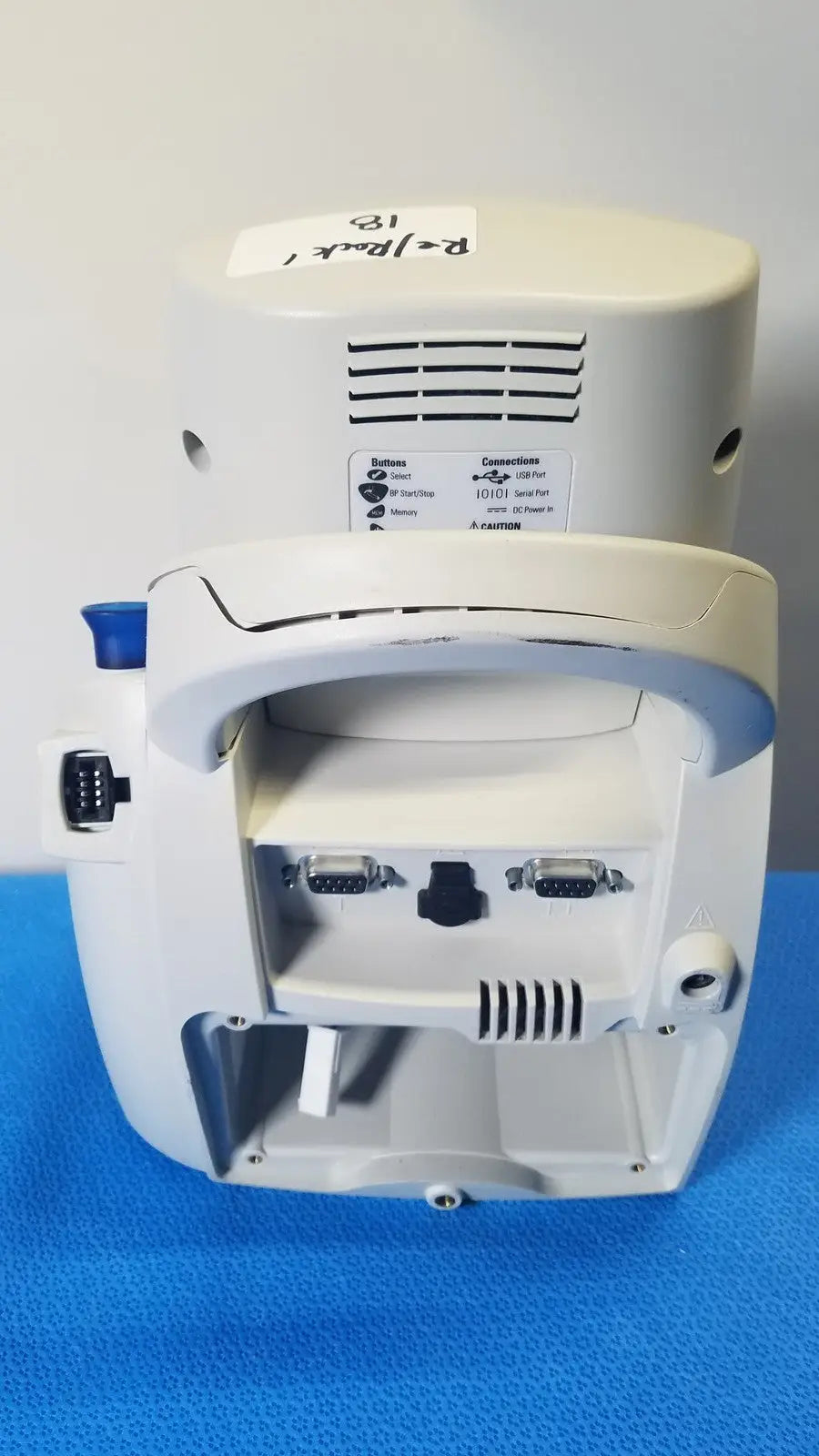White welch allyn spot vital signs lxi medical monitor back side with curved handle and multiple ports visible