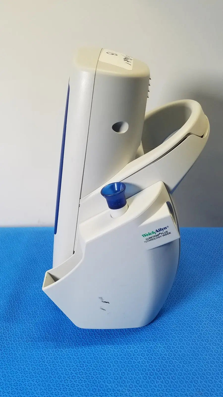 White plastic welch allyn spot vital blood pressure monitor with blue cap on cuff attachment point