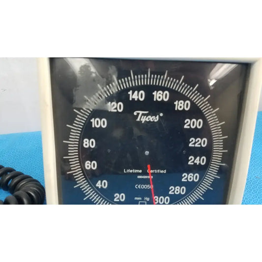 Black analog welch allyn tycos mount aneroid blood pressure monitor gauge with white markings and red needle
