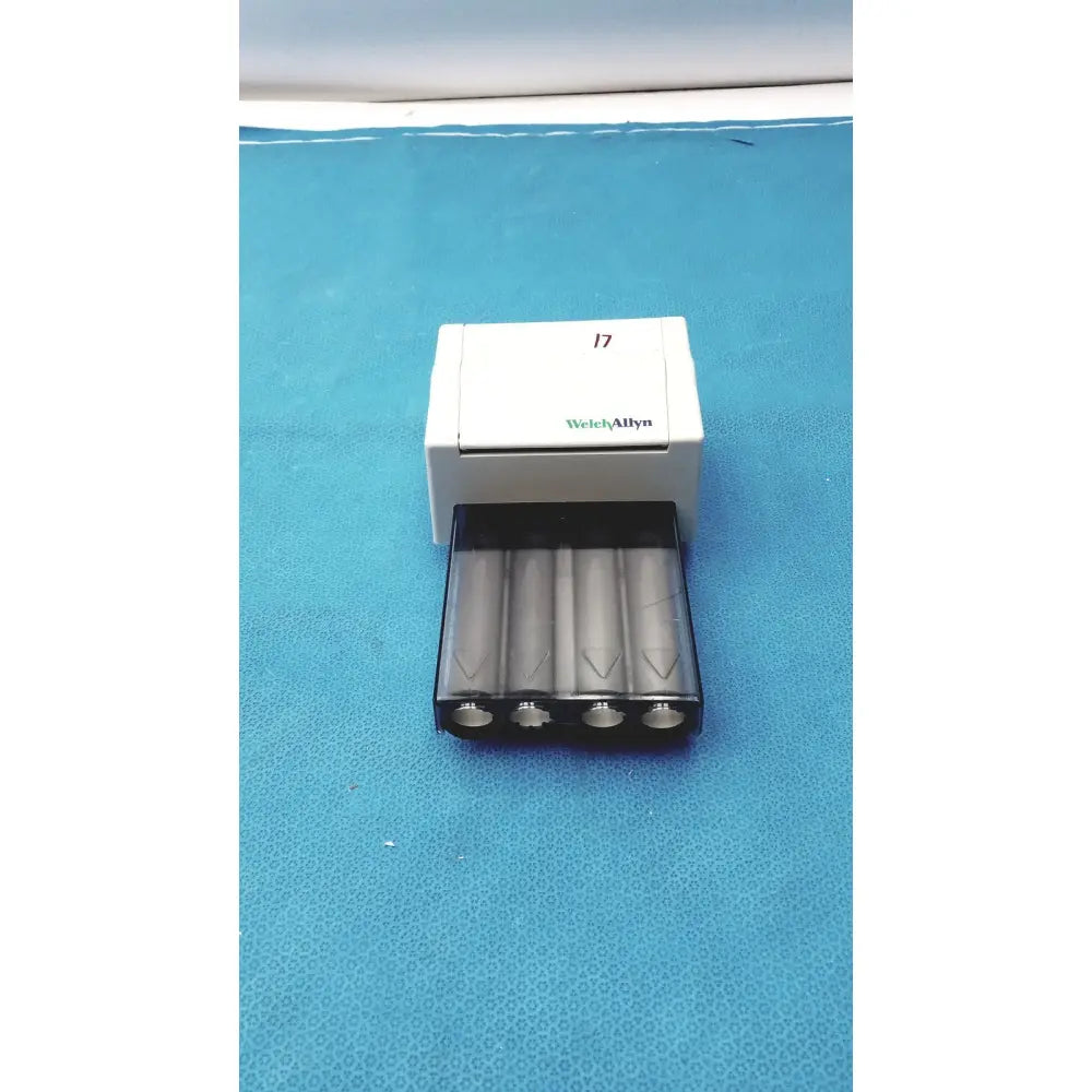 White and black welch allyn universal battery charger with four silver aa batteries in tray for allyn universal kleenspec single use