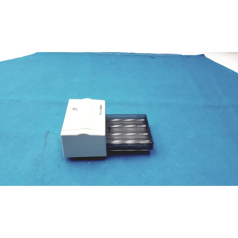 White rectangular welch allyn universal kleenspec single use specula dispenser with black translucent tray holding tubes