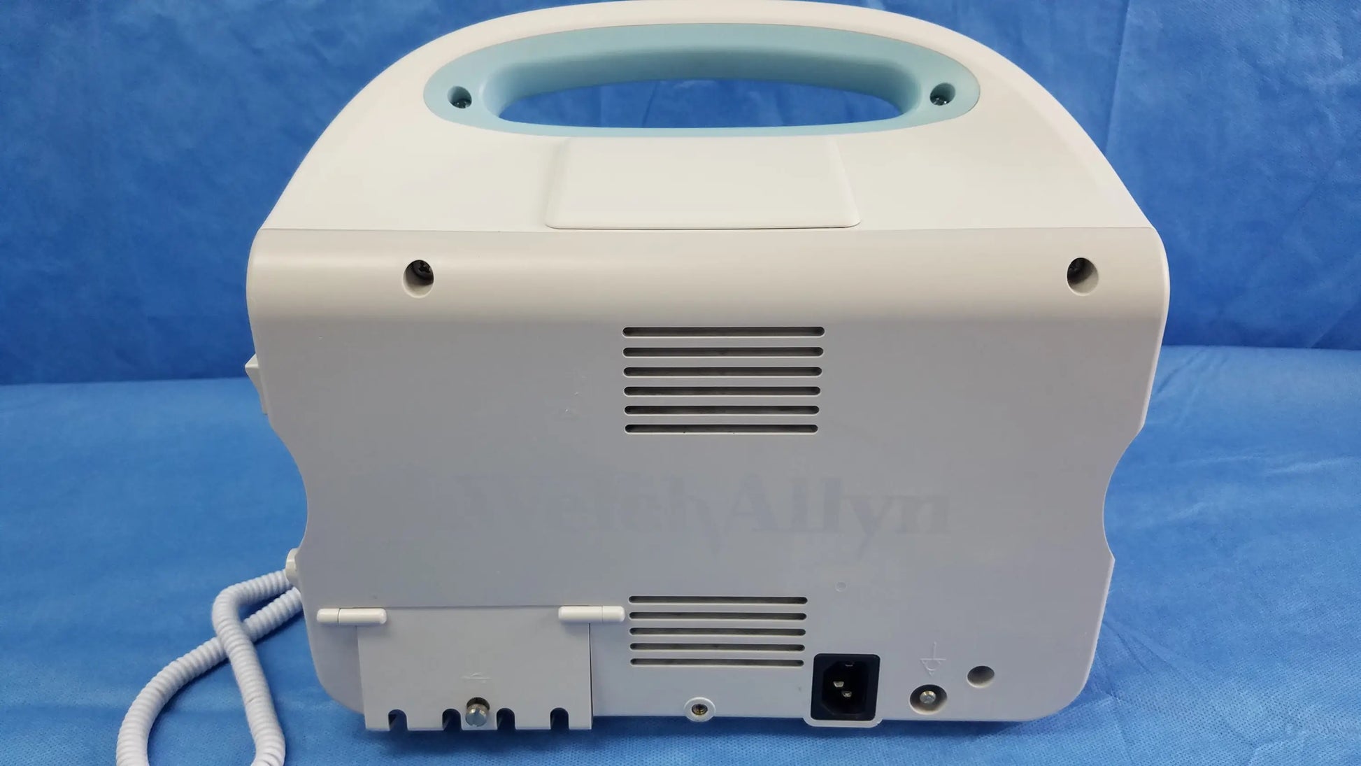 White welch allyn vital signs monitor 6000 series with light blue handle, ventilation slits, power port, and blood pressure cuff cables