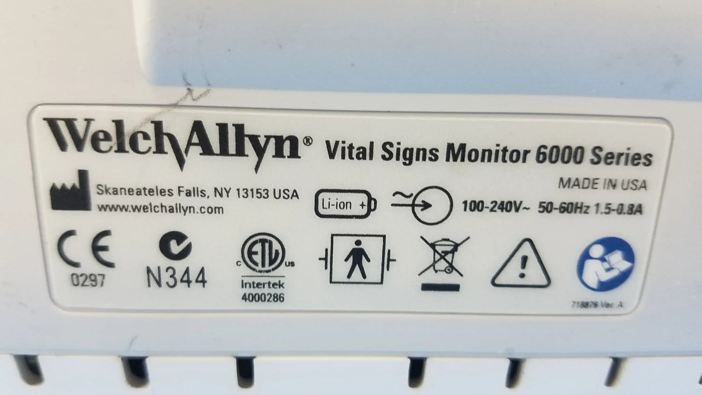 White welch allyn vital signs monitor 6000 series with cables blood pressure cuffs and technical specifications label visible