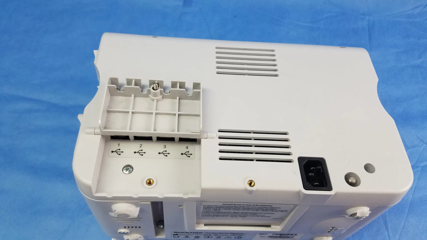 White plastic welch allyn vital signs monitor 6000 series back with compartmentalized tray ventilation slits and electrical plug used for blood pressure cuffs