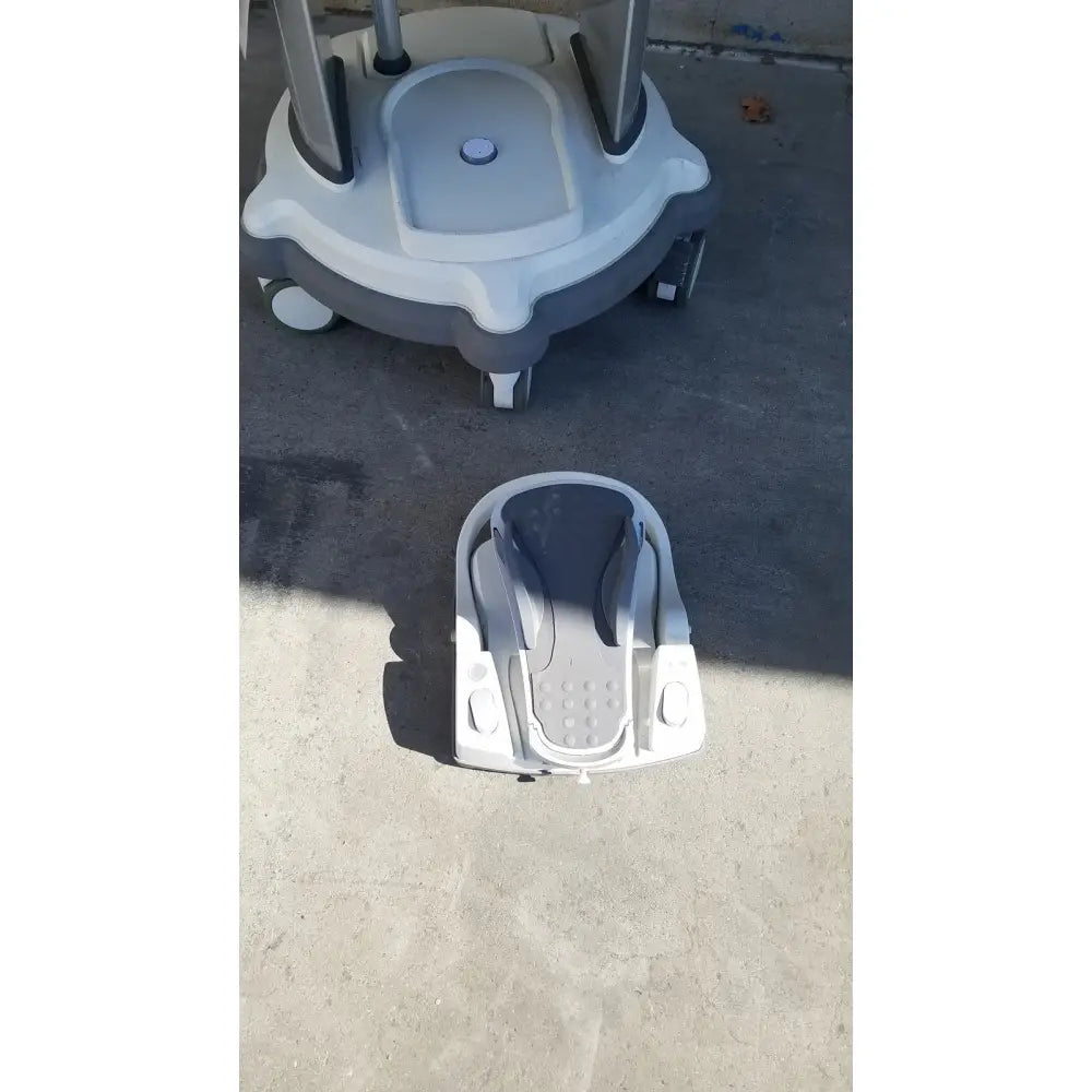 Gray and white plastic baby walker with black accents shown alongside whitestar signature phacoemulsifier for reuse medical use