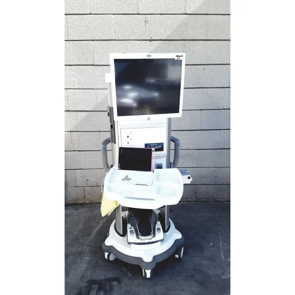 White medical cart with mounted monitor labeled migal on whitestar signature phacoemulsifier with footswitch