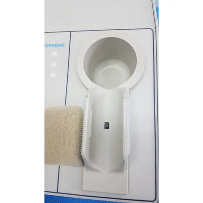White plastic cup holder with beige textured strap attached to williams 6100 ultrasound therapeutic device side