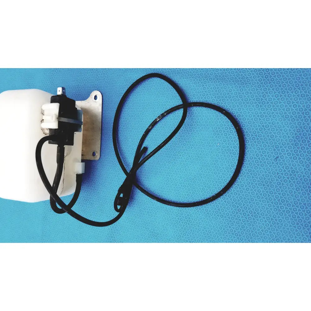 White plastic windshield washer fluid reservoir tank with black electrical connector and coiled cable on metal bracket