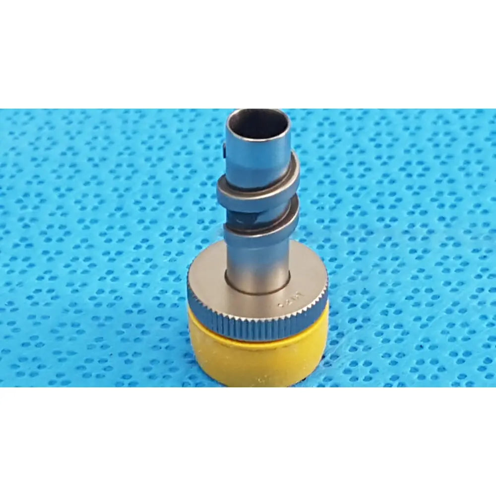 Yellow and silver wolf stainless luer-lock tube connector with textured grip ring for surgical instrument fitting