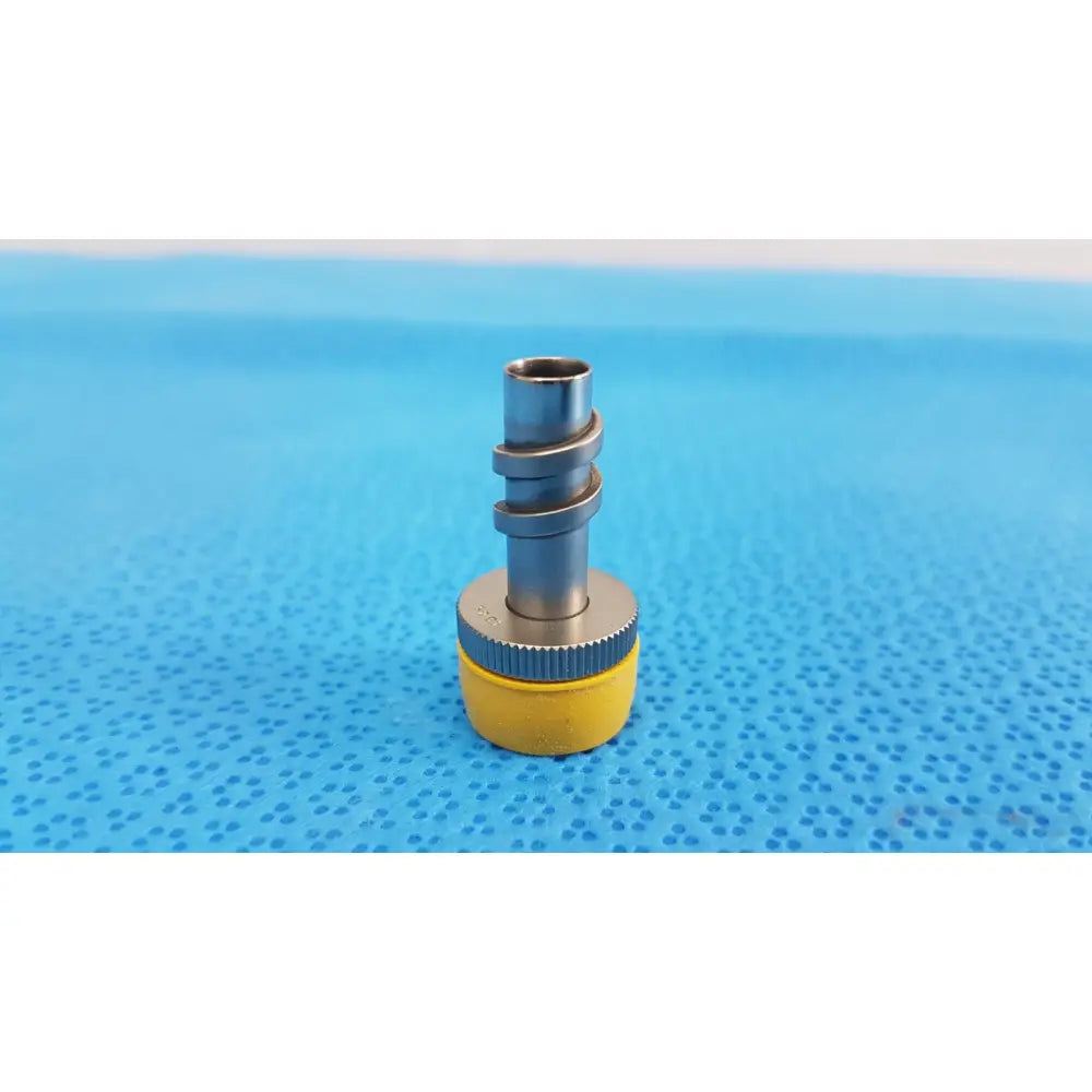 Yellow and silver wolf stainless luer-lock tube connector with threaded metal fittings for surgical instrument use