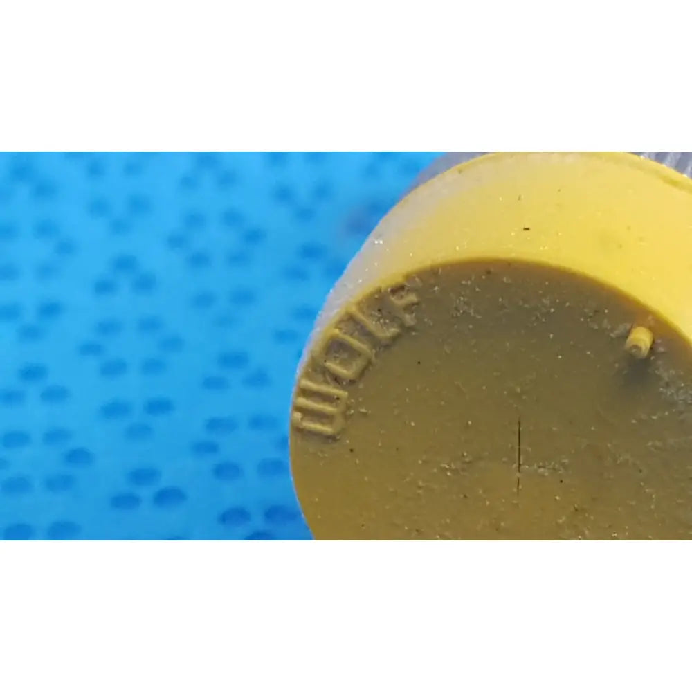 Yellow plastic bottle cap with embossed wolf branding and central indentation for wolf stainless luer-lock tube connector