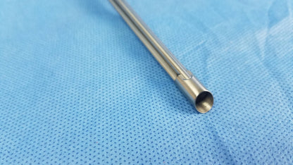 A sleek metallic working insert endoscopic instrument with a hollow stainless steel shaft in olympus sterilization tray