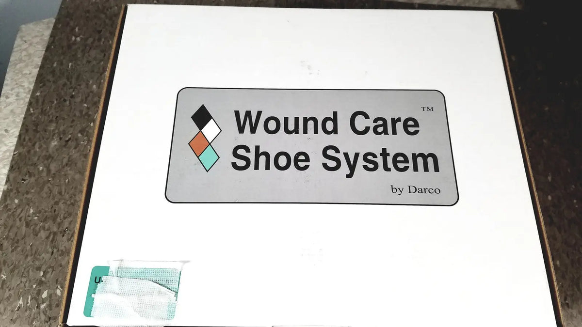White cardboard wound care shoe system box by darco with gray logo featuring black, white, orange, and teal diamonds