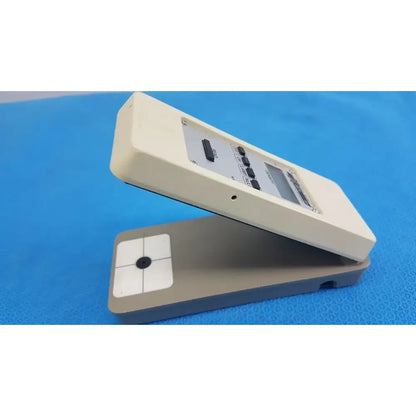 Cream-colored plastic battery operated x-rite 331 transmission densitometer with gray base and black buttons for precision measuring