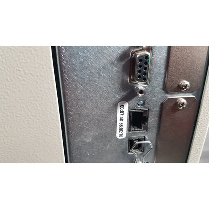 The back side of a silver metal zebra 105sl plus usb ethernet thermal transfer label printer panel with rs-232 and ethernet ports