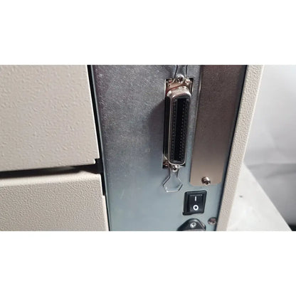 A metallic d-sub connector with black insert on the gray panel back of zebra 105sl plus usb label printer