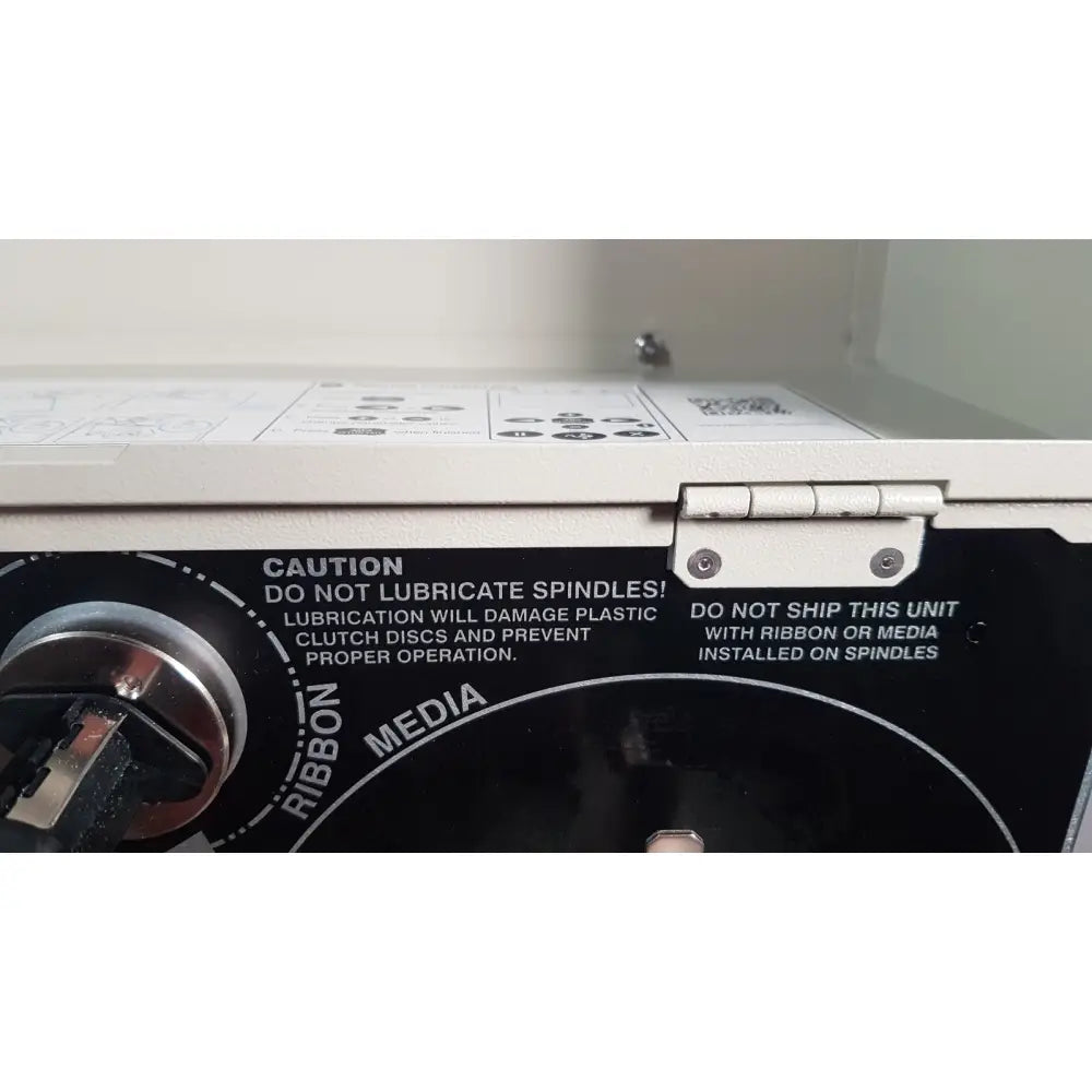 White plastic zebra 105sl plus usb label printer with silver metal hinge and black warning label on back side