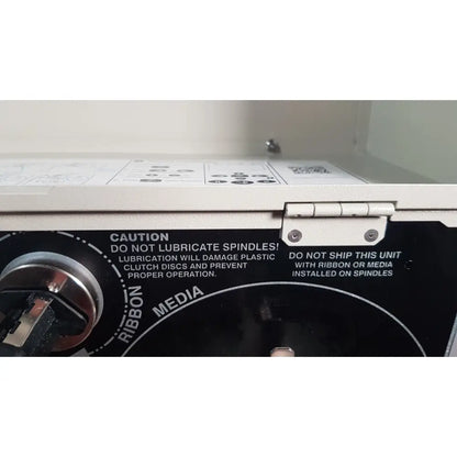 White plastic zebra 105sl plus usb label printer with silver metal hinge and black warning label on back side